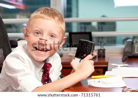 Cute young boy in business clothing in a business office with a funny expression and missing tooth.
