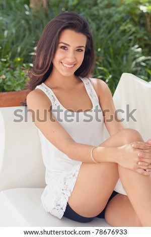 Beautiful young woman in a outdoor garden patio setting.