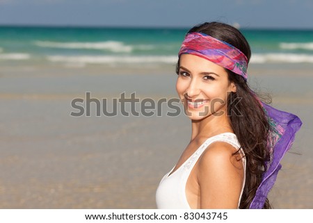 Beautiful young woman wearing a purple bandana enjoying the South Beach shoreline in Miami.