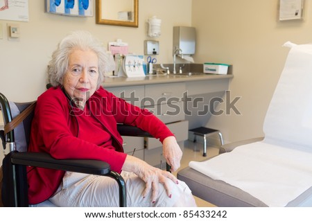 Elderly 80 year old woman with Alzheimer waiting for her doctor in the examination room.