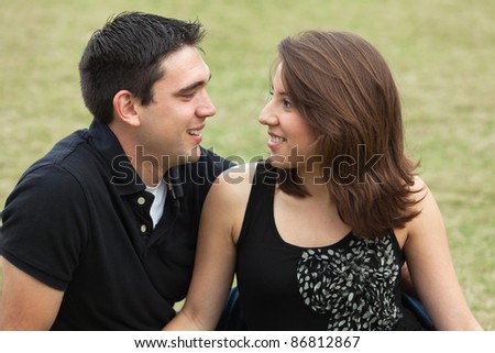 Attractive young married couple outdoors in a park setting.