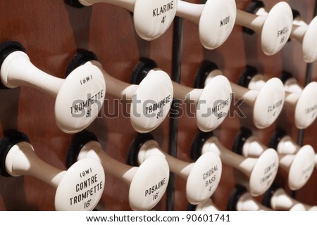 Close up view of the stop knobs of a church pipe organ.