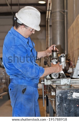 Industrial area. The auto electrician repairs the generator.