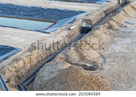 Plastic pipes being placed under ground for water supply for industrial site.