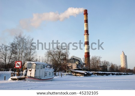 old Ship on frozen river with traffic sign, chimney and modern building