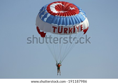 The tourist on a parachute with to Turkish symbolics in the blue sky