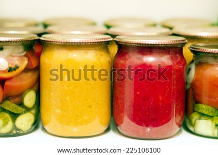 Various canning vegetables in glass jar on a shelf in the pantry