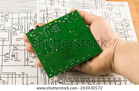 Chip green in hands on background drawings circuits