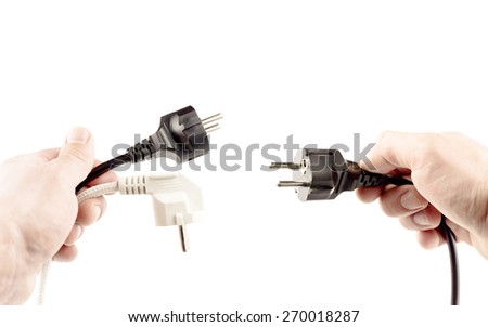 White and black plugs in hands on a white background