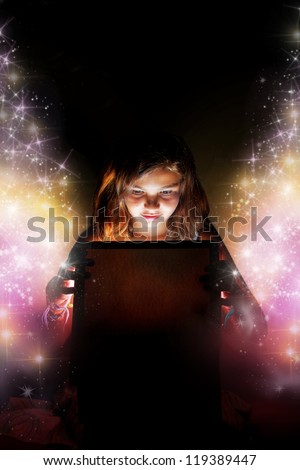 A little girl opening a magic box/present setting the stars free. Christmas or birthday concept Ã?Â¢?? the magic of gifts.