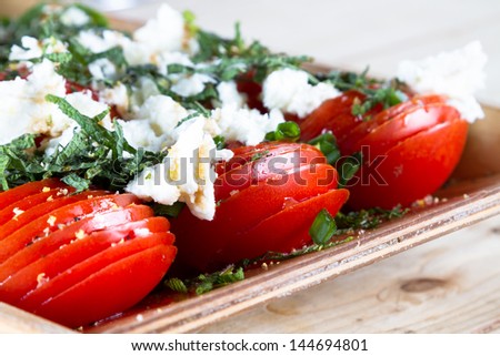 Spring recipes: fresh tomato salad with mozzarella cheese and mint leaves.