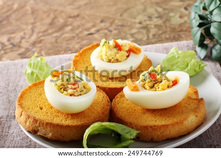 Egg stuffed with pepper, chives, mayonnaise on complex background