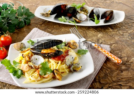 Spaghetti with salmon, clams and mussels on complex background