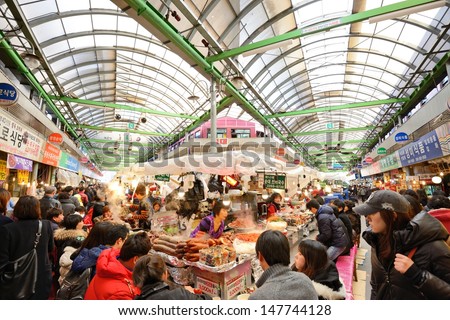 SEOUL - FEBRUARY 16: Shoppers pass through Gwangjang Market February 16, 2013 in Seoul, South Korea. The market dates from 1905 and offers a glimpse into traditional markets of the country.