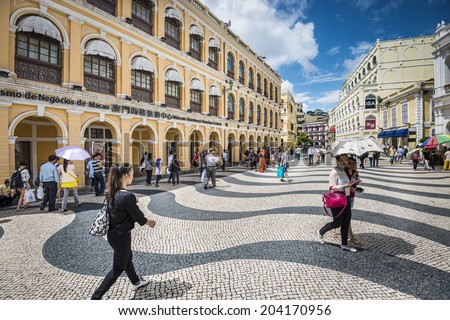 MACAU, CHINA - MAY 21, 2014: Pedestrians stroll down Senado Square. The territory was the last European colony in Asia and the architecture is inspired by the former Portuguese rule.