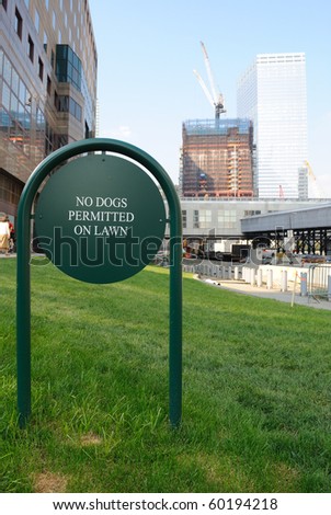 A sign reading no dogs permitted on lawn in new york city.