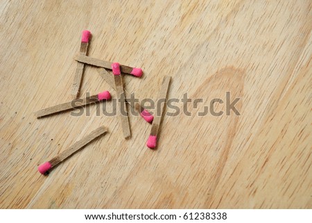 Pink tipped matches on a wooden table top.