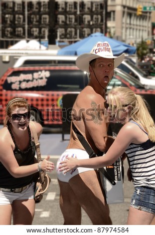 NEW YORK CITY - AUGUST 24: Naked Cowboy posing with tourist on August 24, 2011 in New York, NY.  The Naked Cowboy has run for various government positions including the 2012 presidential candidacy.
