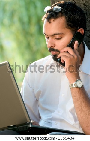 Indian guy with a mobile phone and laptop