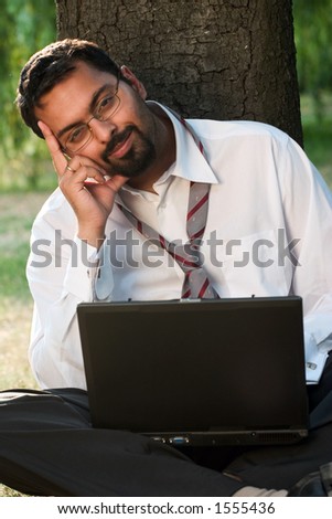 Indian guy with laptop looking ahead