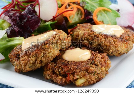 Freshly cooked crab cakes with baby greens salad
