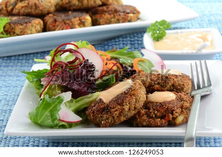 Freshly cooked crab cakes with baby greens salad
