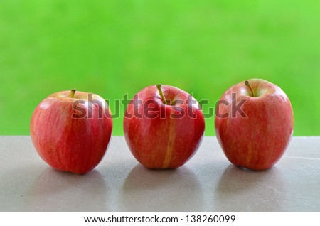 Delicious Gala apples on windowsill with vibrant green background