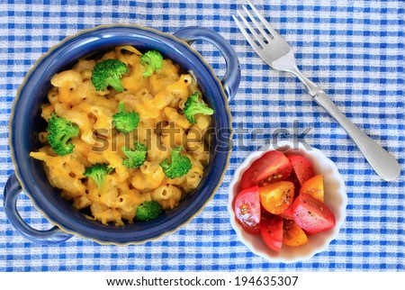 Healthy whole wheat macaroni with cheddar cheese sauce, broccoli and cherry tomatoes
