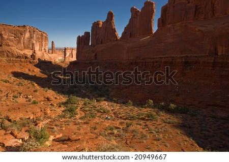 Hikers on the trail through scenic Park Lane sandstone formation at Arches National Park, Utah