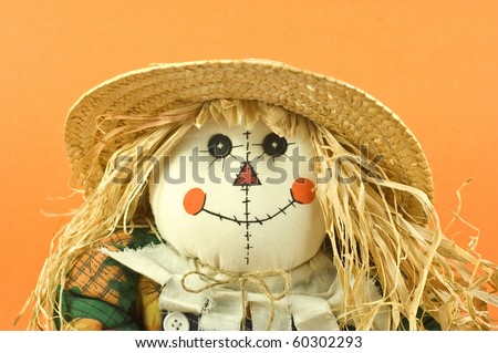 Halloween or Thanksgiving theme straw doll on orange background