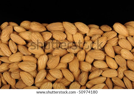 Numerous almonds arranged in a pie for a product photograph. Almonds are considered healthy and good for the heart.