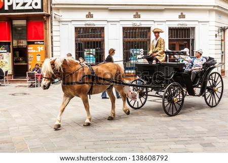 BRATISLAVA, SLOVAKIA - MAY 9: Tourists in a horse carriage in Old Town on May 9, 2013 in Bratislava, Slovakia. Bratislava is the most populous (462,000) and most visited city in Slovakia.
