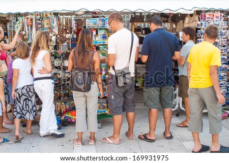 ZADAR, CROATIA - AUGUST 19, 2007: Tourists in front of the newsstands with papers and postcards on the streets of Zadar.