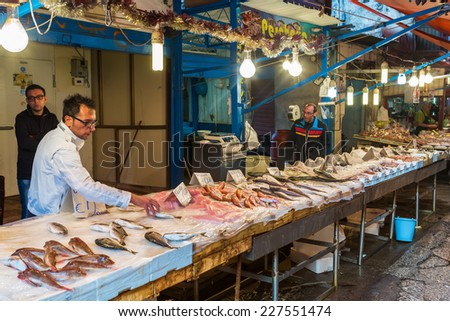 PALERMO, ITALY - OCTOBER 23, 2014: Sellers on fish stand on Ballaro farmer\'s market on  streets of old Palermo city center, around Plaza Carmine. It is  oldest of Palermo\'s Arabic markets.