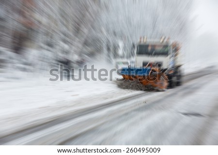 Abstract background -   snow plough cleaning the streets covered in snow and mud during heavy snowfall  - radial zoom blur effect defocusing filter applied