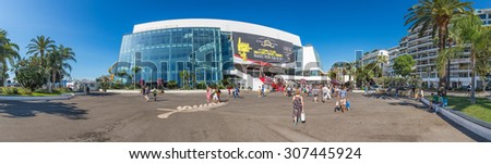 CANNES, FRANCE - AUGUST 17, 2015: People in front of the Cannes Film Festival theatre, a stitched panorama. Cannes is one of the bigest French tourist cities and home to annual film festival.