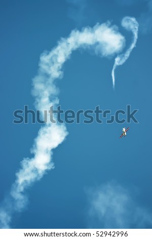 Airplane moving erratically leaving trails of vapour and fuel