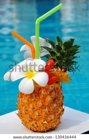 Tropical pineapple cocktail. Drink on the background of the pool.