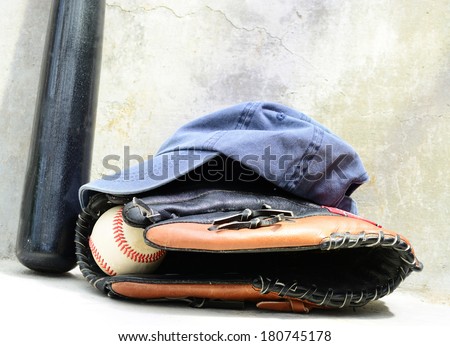 Baseball bat wit a cap and a glove with a ball in it