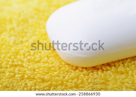 Close up of a white soap bar over a yellow towel