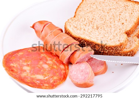 Macro shot of a meal showing sausage and bread on a white background