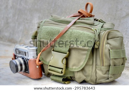 Camera bag and old camera on a gray concrete background