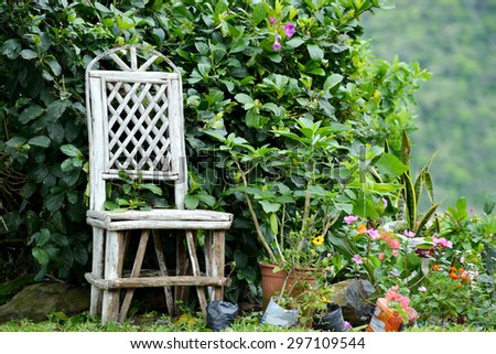 Old gardener chair in a flowering garden in the mountains of Panama