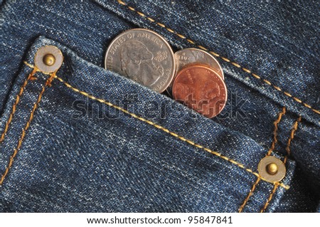 Macro shot of a jean\'s pocket with coins coming out of it