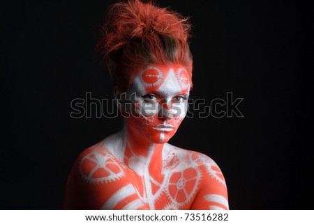 mystic young woman with painted face looking at camera