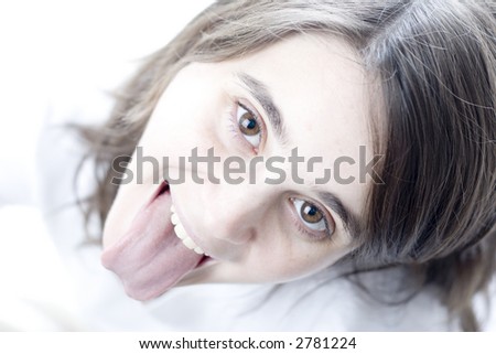 High key portrait of a teen sticking out her tongue