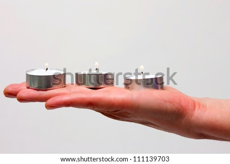 three candles on a hand