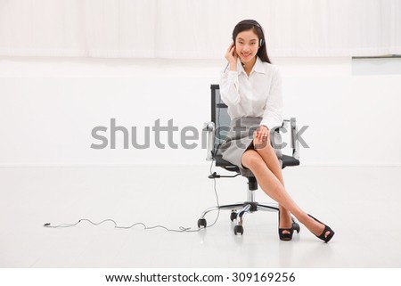 Portrait of a young female customer service executive sitting chair