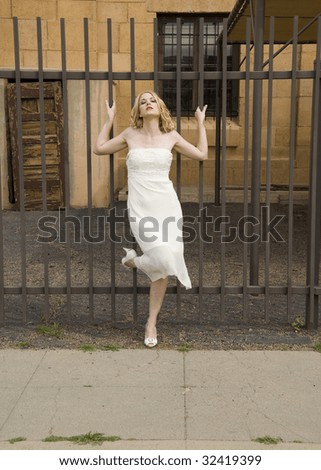Beautiful woman in front of a metal fence