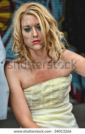 Sad lady in front of a wall of graffiti